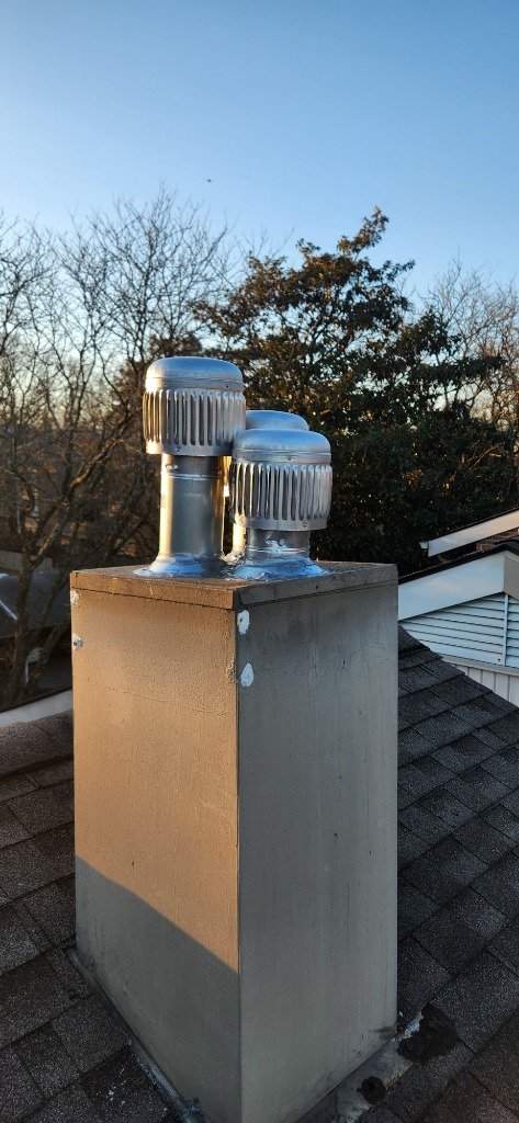 Dual stainless steel chimney caps installed
